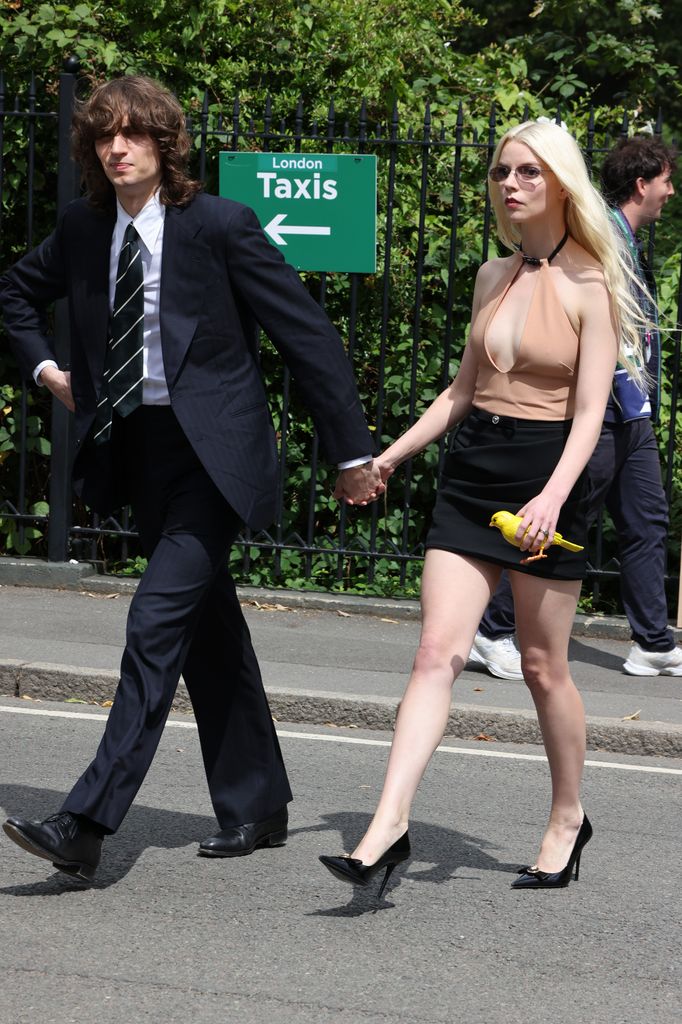 Plano entero de Malcolm McRae y Anya Taylor-Joy llegando al Wimbledon 2024
