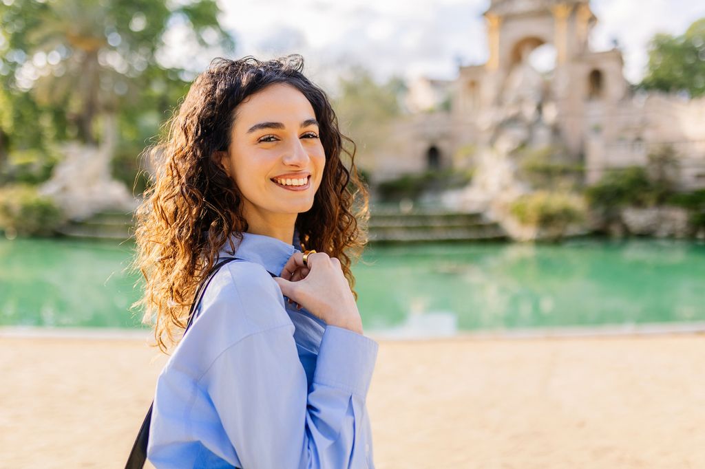 Mujer tranquila y feliz paseando por el Parque Ciudadela de Barcelona