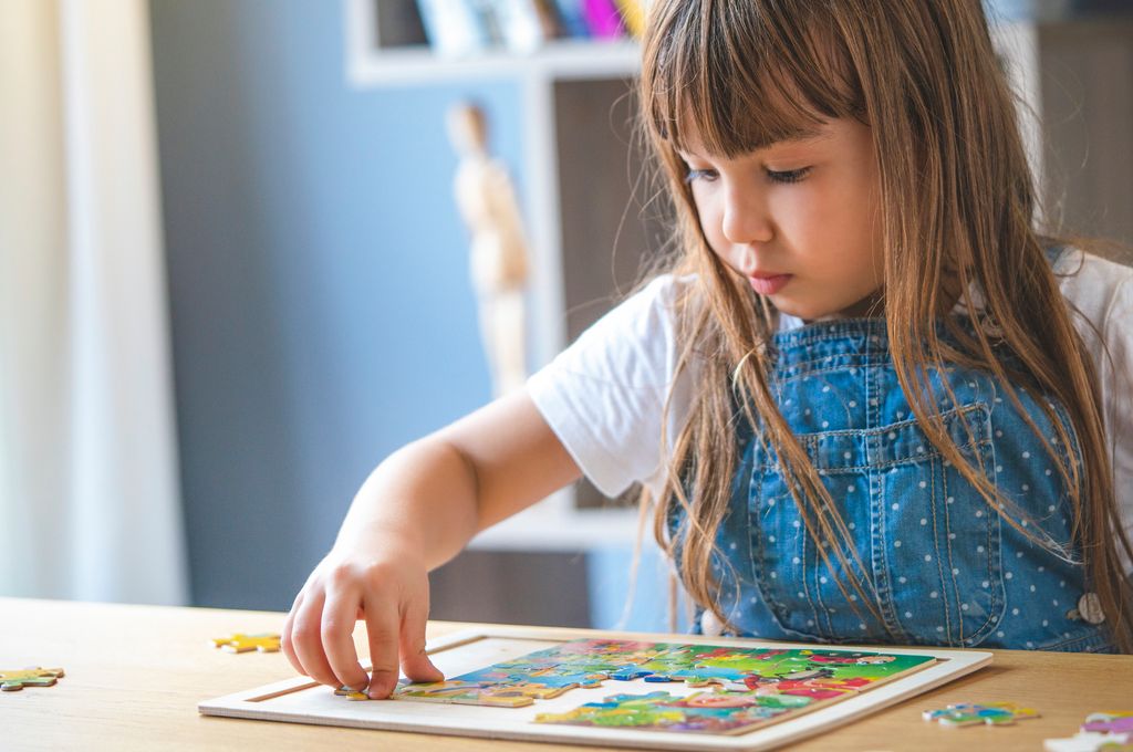 niña jugando con un puzle en su casa