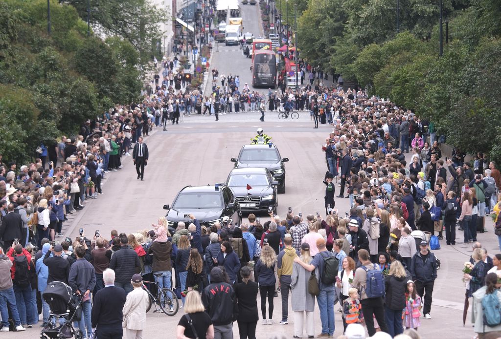 Una comitiva real entra en el Palacio Real mientras una multitud se congrega a lo largo del recorrido en Oslo