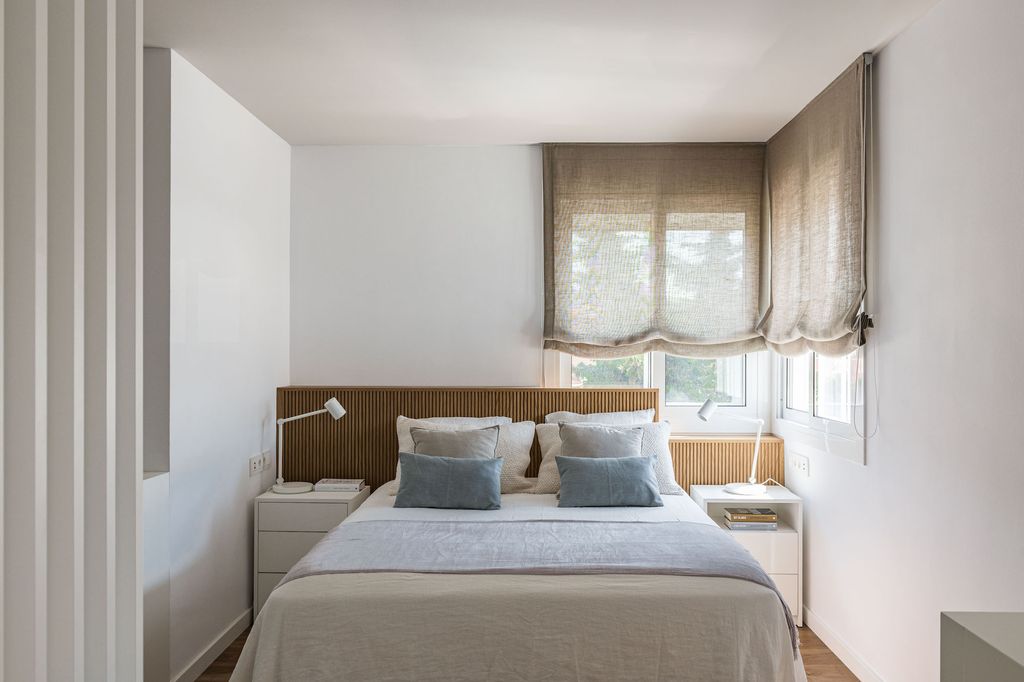 Dormitorio con cabecero bajo la ventana.  