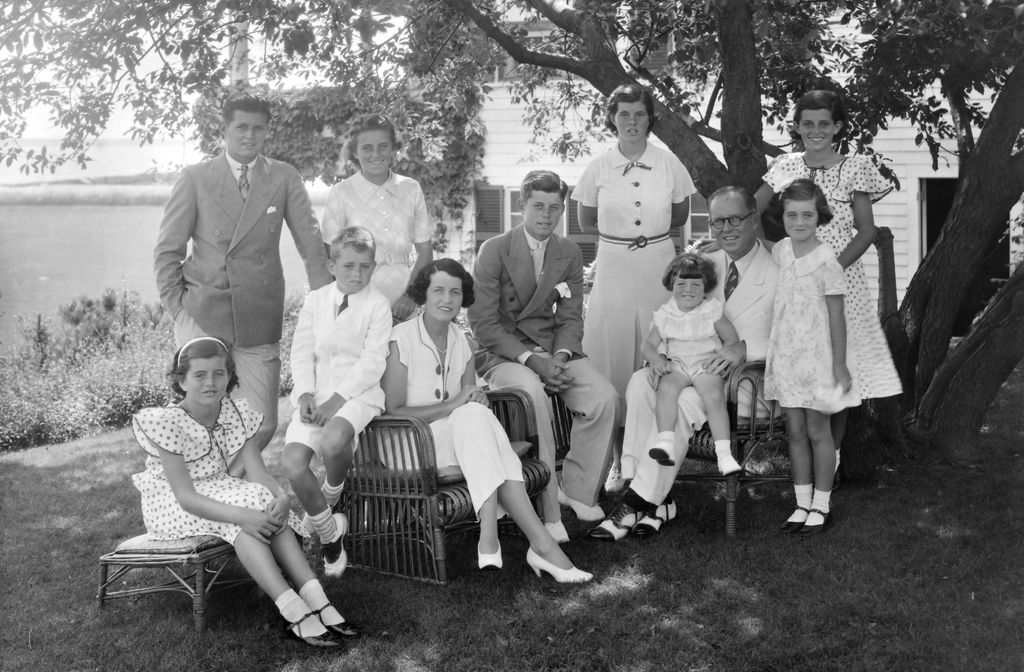 Un retrato de la familia Kennedy. Sentados de izquierda a derecha están: Patricia Kennedy (1926 - 2006), Robert Kennedy (1925 - 1968), Rose Kennedy (1890 - 1995), John F. Kennedy (1917 - 1963), Joseph P Kennedy Sr. (1888 - 1969), sentado en su regazo está Edward Kennedy. Los que están de pie, partiendo desde la izquierda, son Joseph P Kennedy Jr. (1915 - 1944), Kathleen Kennedy (1920 - 1948), Rosemary Kennedy (1918 - 2005), Eunice Kennedy (la que lleva un vestido de lunares) y Jean Kennedy.