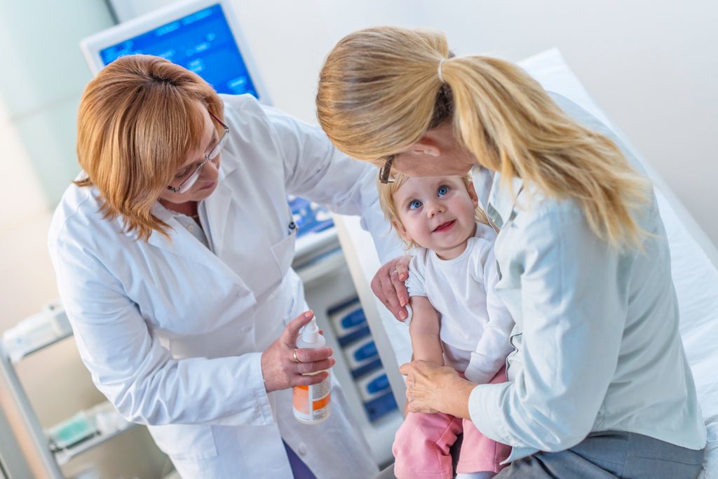 profesional sanitario preparando a un bebé para hacerle unos análisis de sangre
