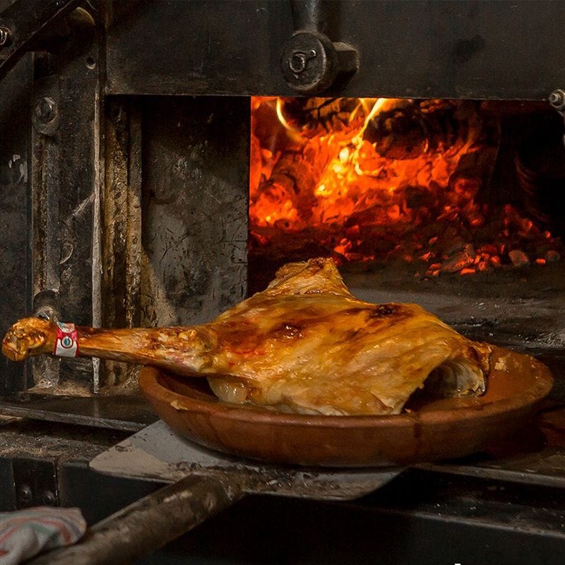 El lechazo asado en horno de leña es el plato más emblemático de la cocina castellana y de La Parrilla de San Lorenzo.