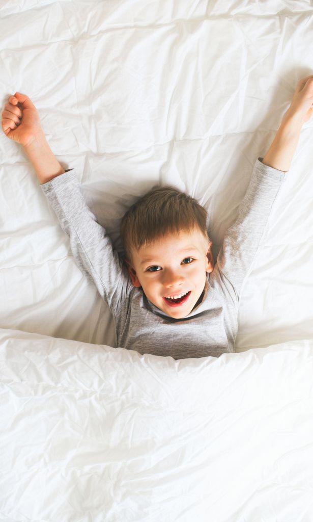 Niño contento en la cama