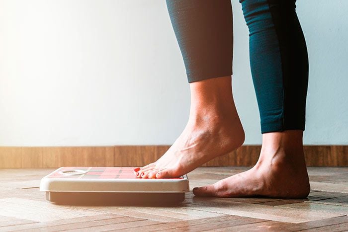 mujer pesándose con la báscula