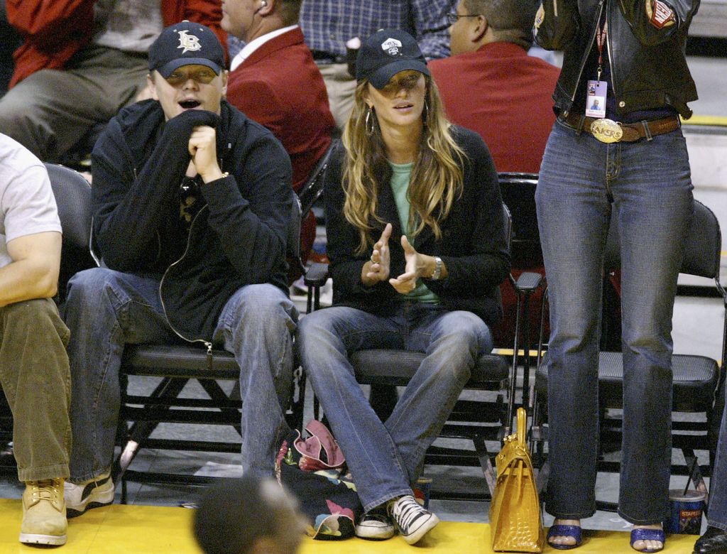 Plano medio de Leonardo DiCaprio y Gisele Bundchen en un partido de baloncesto