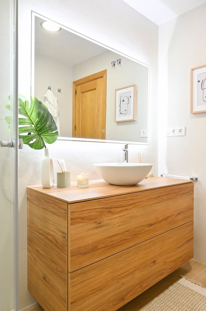 Baño pequeño con espejo iluminado. 