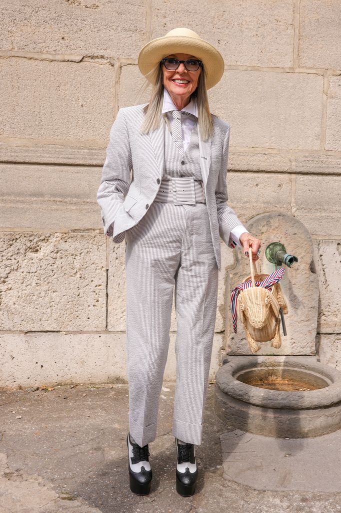 Diane Keaton con traje y bolso en forma de perro, en el desfile de Thom Browne