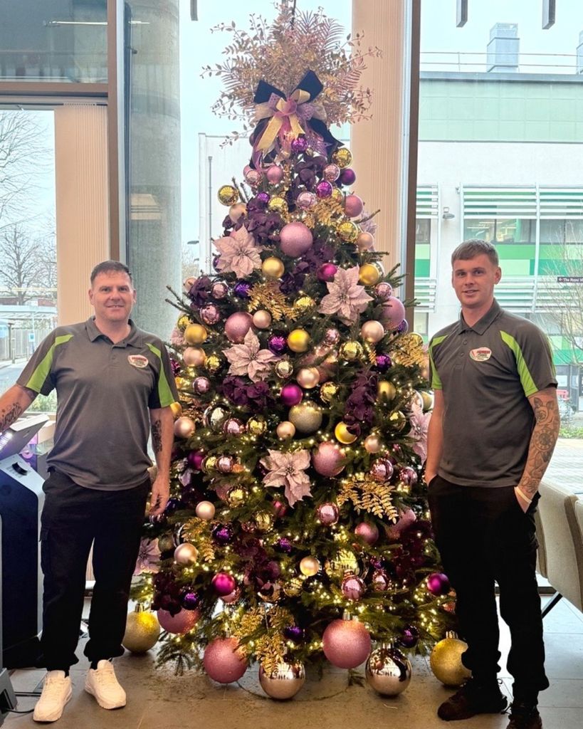 Operarios del centro posan delante del árbol de Navidad de Kate Middleton