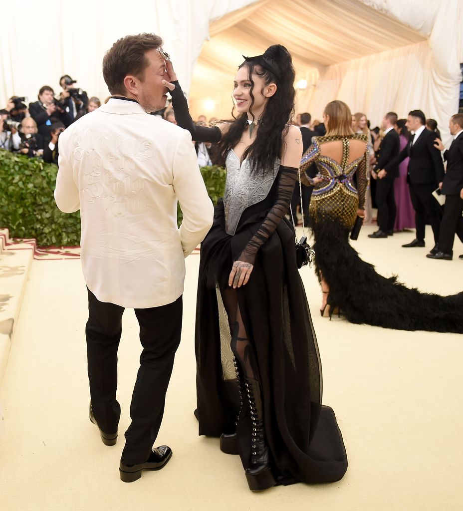 Plano entero de Elon Musk con Grimes en un evento