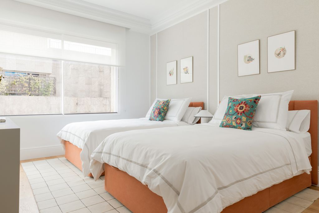 Dormitorio de dos camas en blanco y naranja