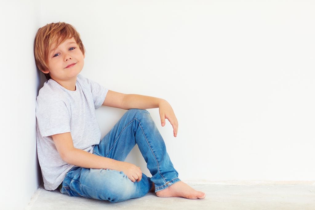 Niño pequeño sentado en el suelo