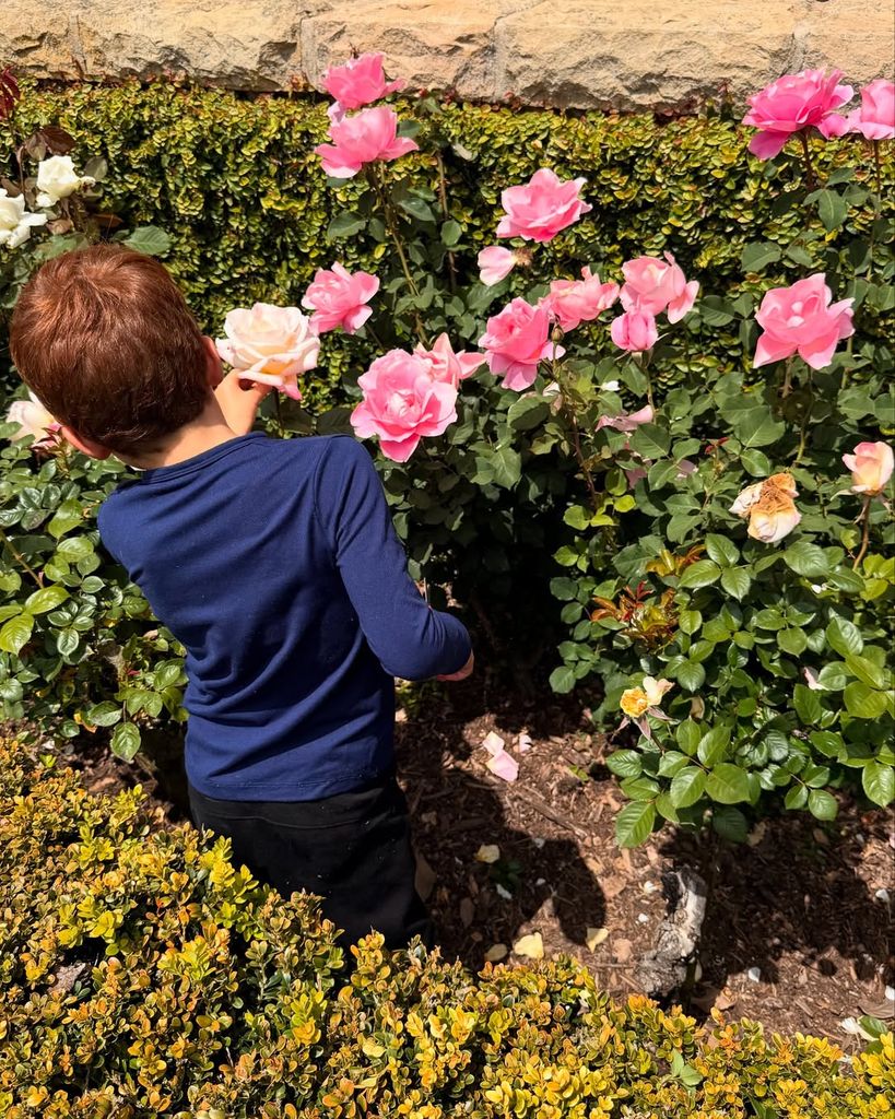Archie Harrison cogiendo una flor en el jardín de la casa familiar