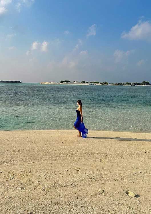 Tamara Falcó mirando al mar con un vestido azul 