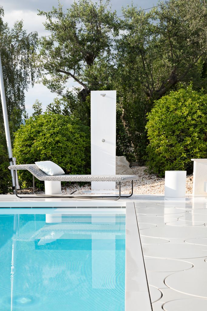 Piscina rodeada de arbustos y árboles