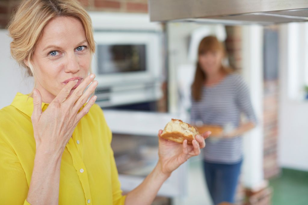 Mujer comiendo dulce en la cocina 