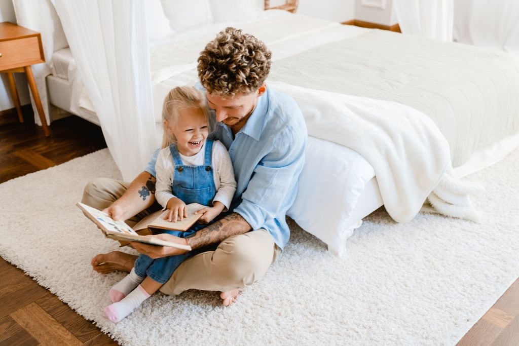Padre leyendo con su hija pequeña en casa