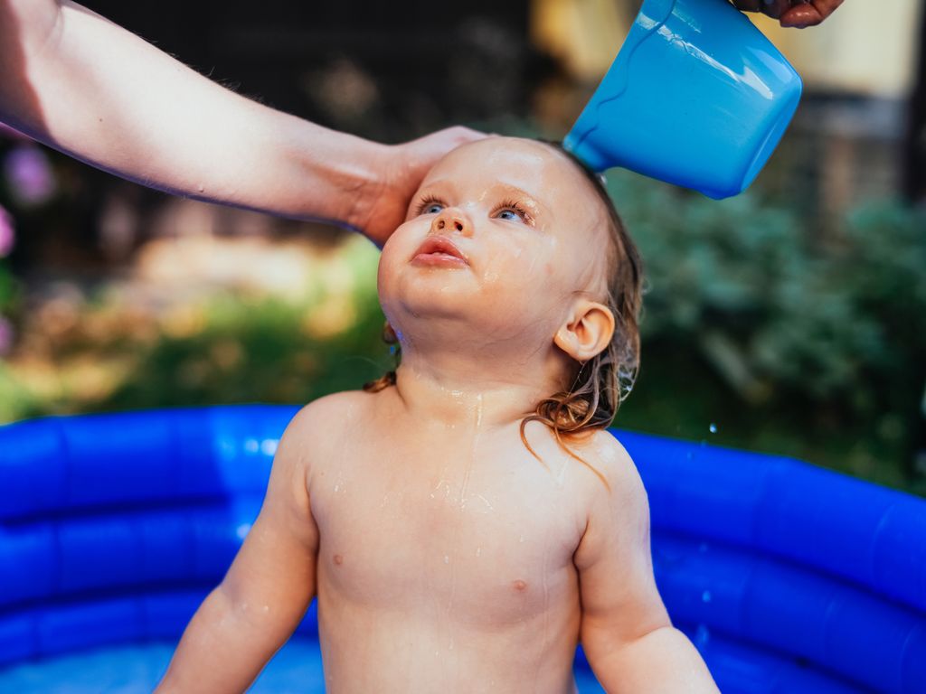 Bebé refrescándose en una piscina en verano