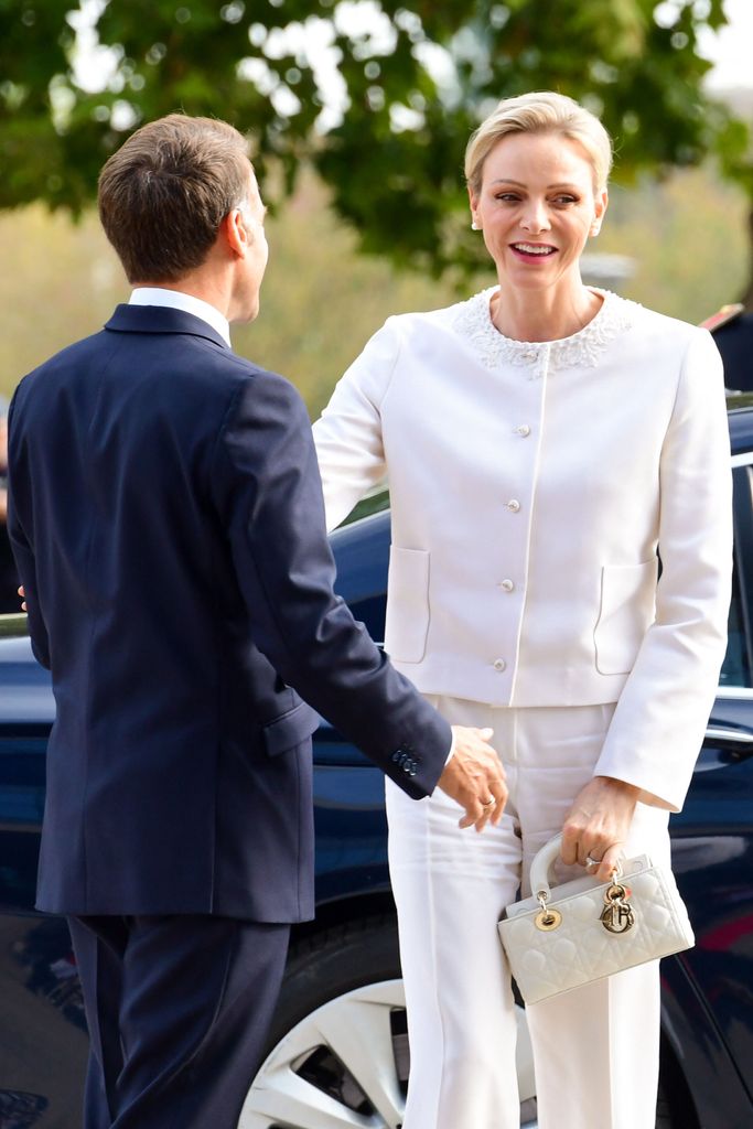 Charlene de Mónaco, con traje blanco, saluda a Emmanuel Macron en su visita a Francia