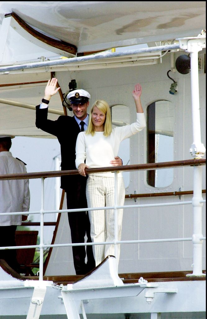 Haakon de Noruega y la princesa Mette-Marit el día antes de su boda saludando desde el barco real el 24 de agosto de  2001
