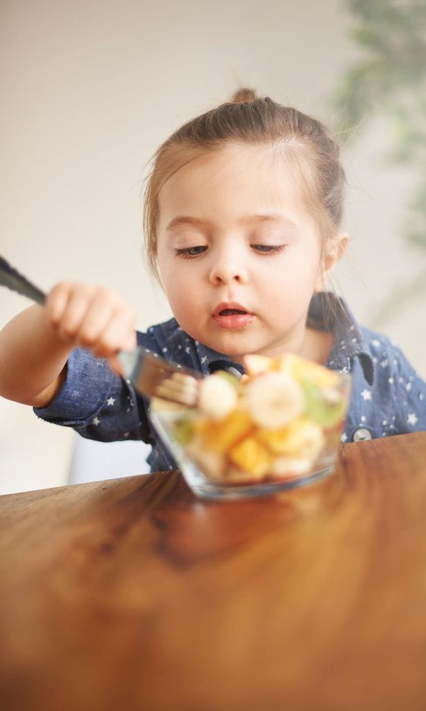 Niña comiendo fruta