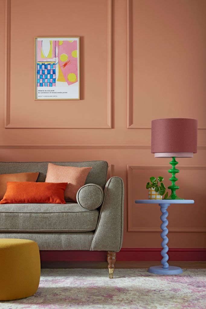 Salón con pared de color salmón y muebles de colores