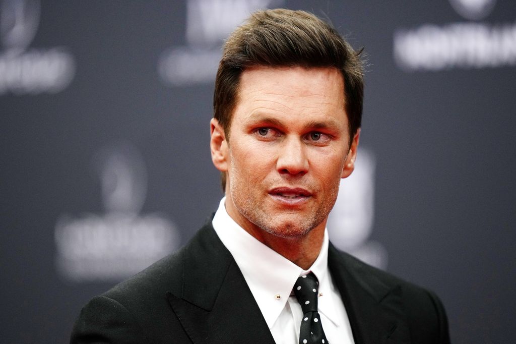 Primer plano de Tom Brady con traje negro y corbata de lunares