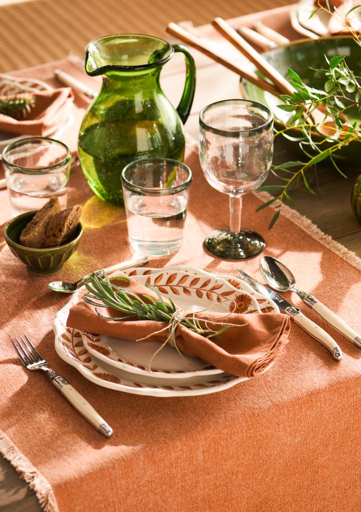 Mesa con mantel y vajilla en tonos terracota