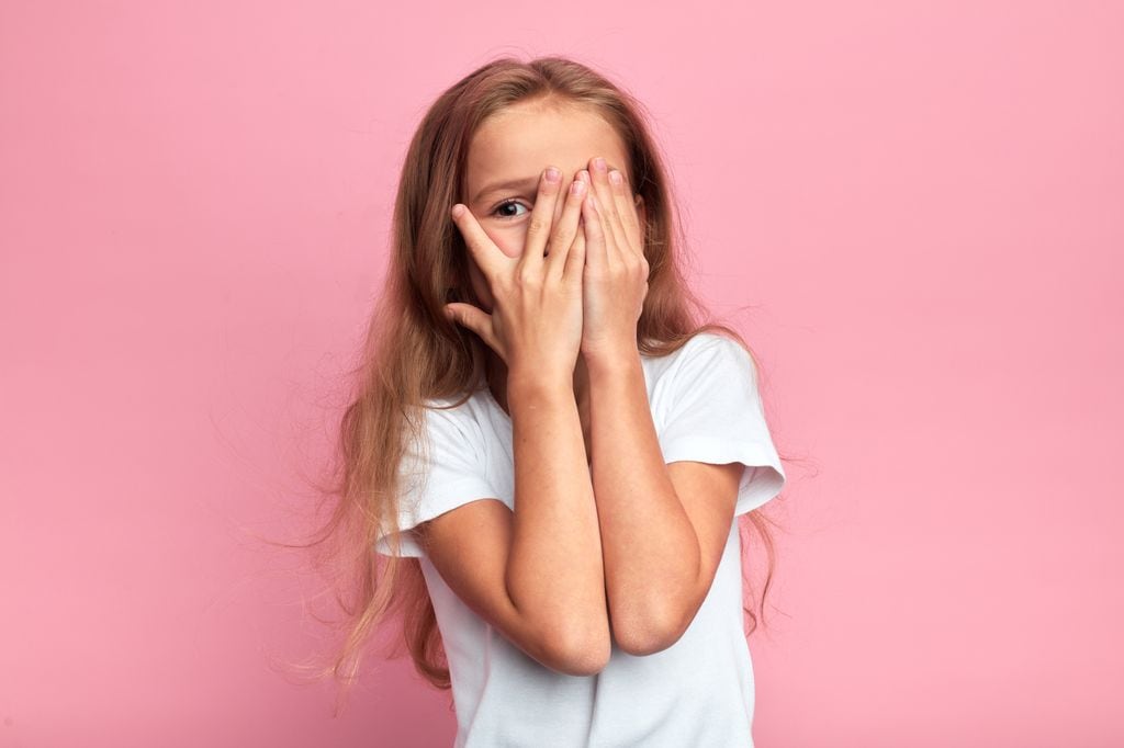 Niña tímida tapándose la cara