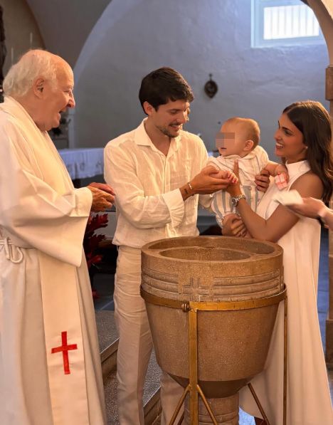 El matrimonio y su niño, con el párroco dentro de la iglesia
