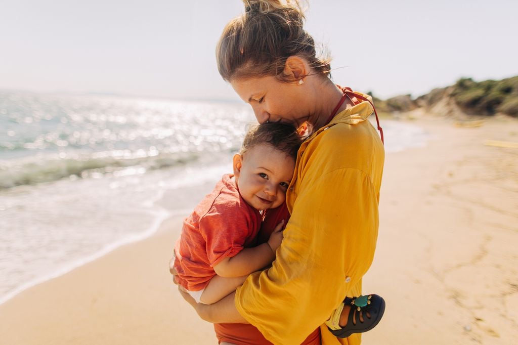 Madre besa a su hijo en la playa