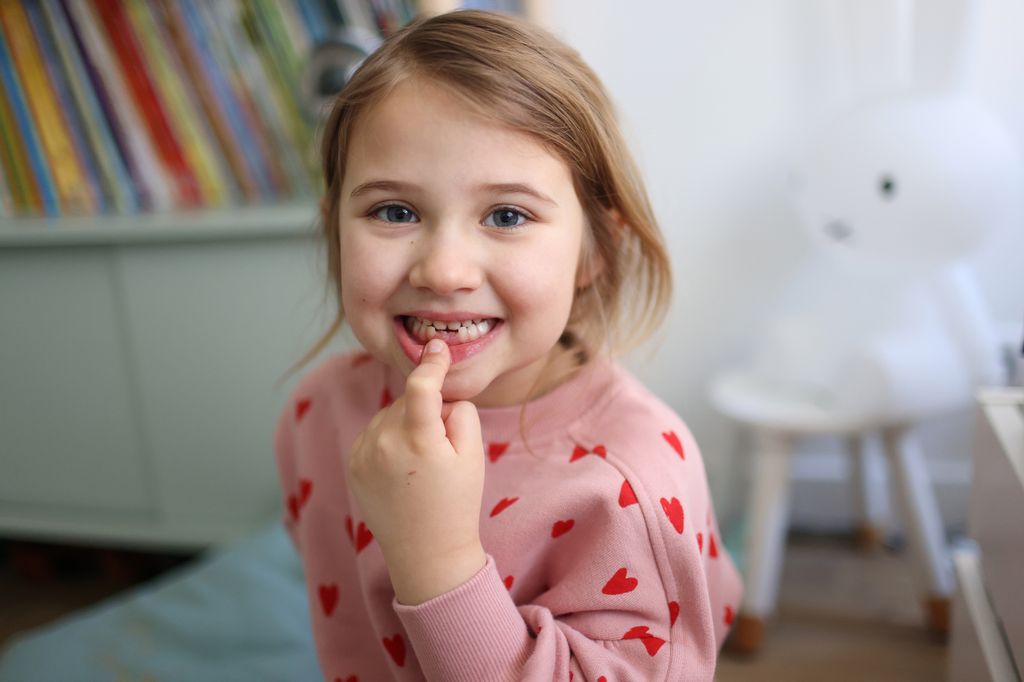 Niña de 5 años tocándose los dientes