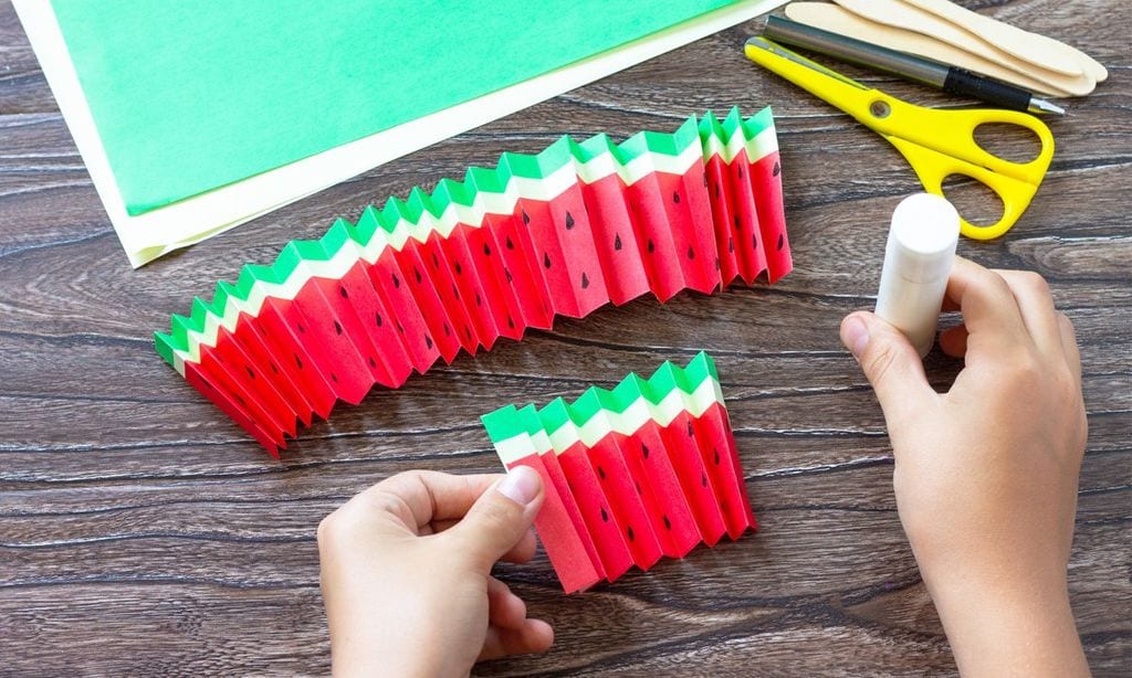 Manualidades: hacer un abanico de sandía con cartulinas.