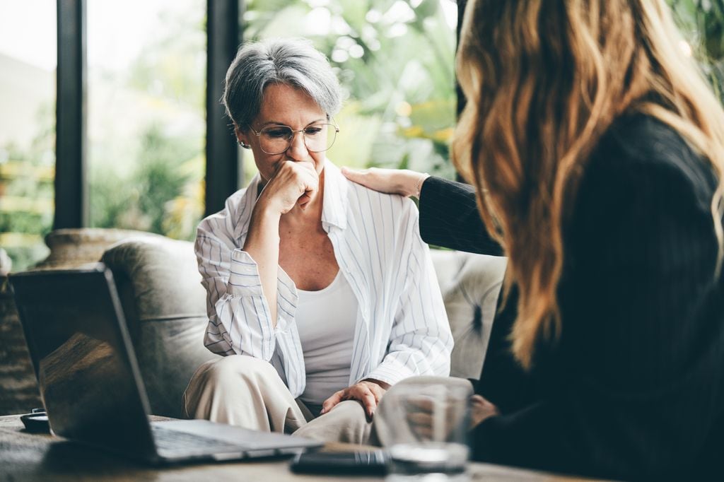 mujer de mediana edad hablando en consulta con una psicóloga, recibiendo su apoyo