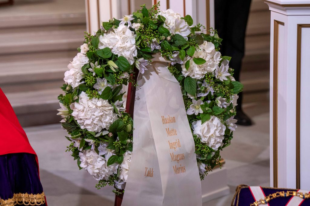 Corona de flores junto el féretro del rey Harald con la plabra takk (gracias, en noruego) y los nombres de Haakon, Mette, Ingrid, Magnus y Marius
