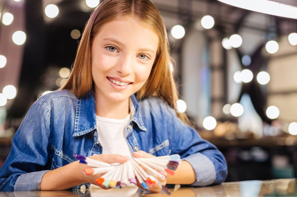 Adolescente eligiendo color de uñas