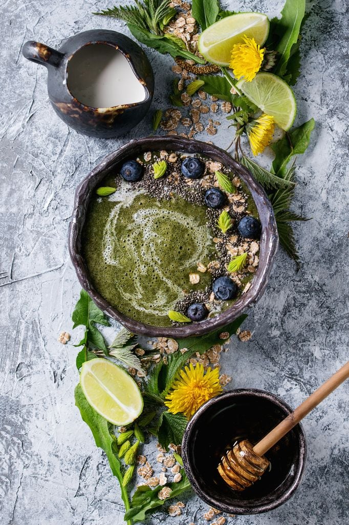 Smoothie en un bowl con frutos del bosque, semillas y miel