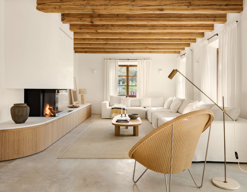 Salón blanco con vigas de madera en el techo