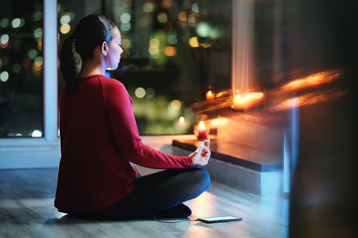 mujer haciendo yoga por la noche