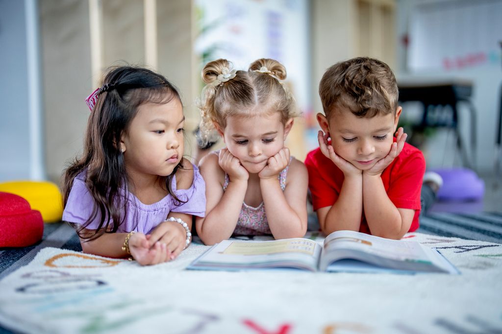 Niños pequeños delante de un libro