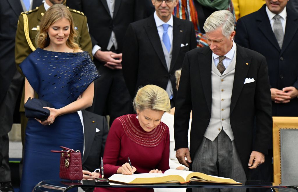 Matilde de B´legica firmando en el libro tras la abdicación del gran duque Enrique ante la mirada de su marido, Felipe de Bélgica, y su hija, Elisabeth de Bélgica