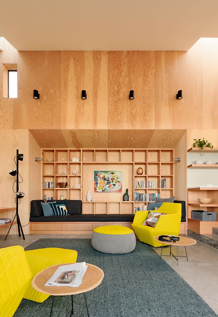 Salón con estantería de madera en el mismo acabado de la pared