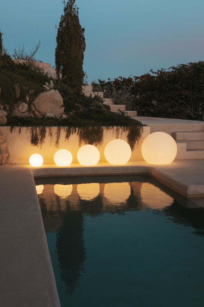 Lámparas esféricas junto a la piscina