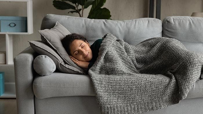 mujer echándose la siesta en el sofá