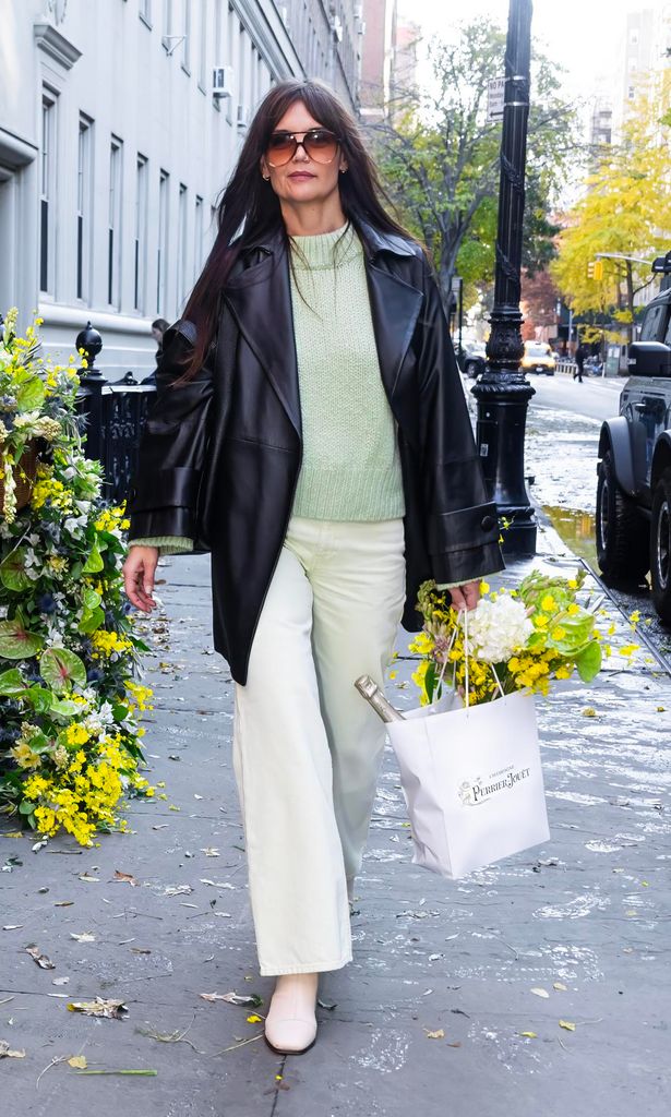katie holmes con un sueter verde claro durante una caminata por nueva york