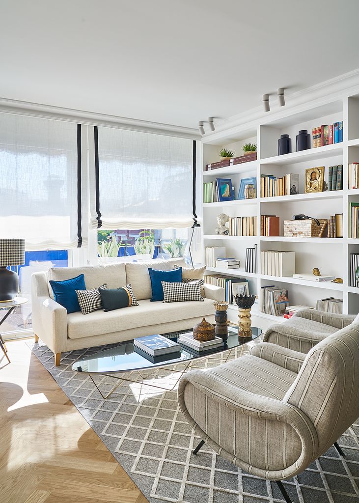 Salón con sofás blancos y cojines azules.  