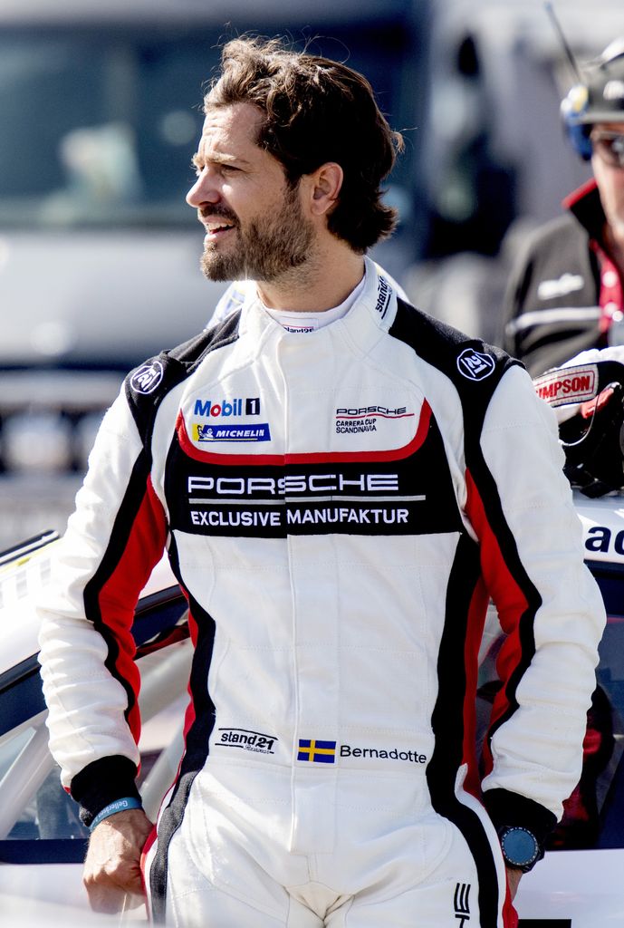 El príncipe Carlos Felipe de Suecia vestido con un mono de piloto de Porsche.