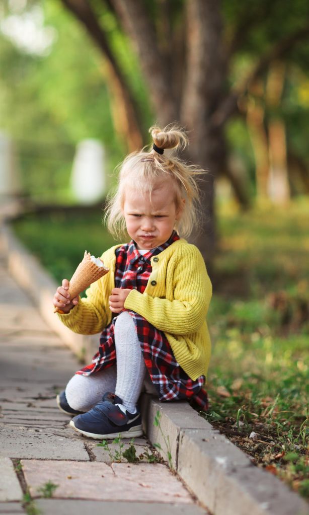 Niña enfadada con helado en la mano