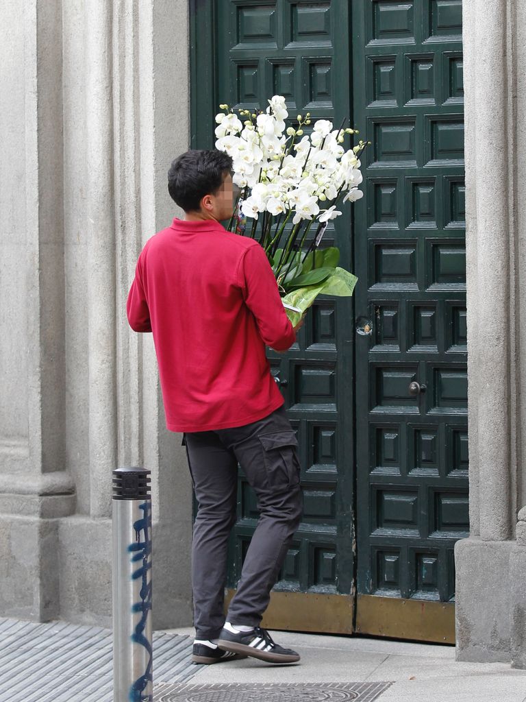 Un repartidor entrega un ramo de flores en la casa de Sofía Palazuelo tras dar a luz a su tercer hijo, Fernando